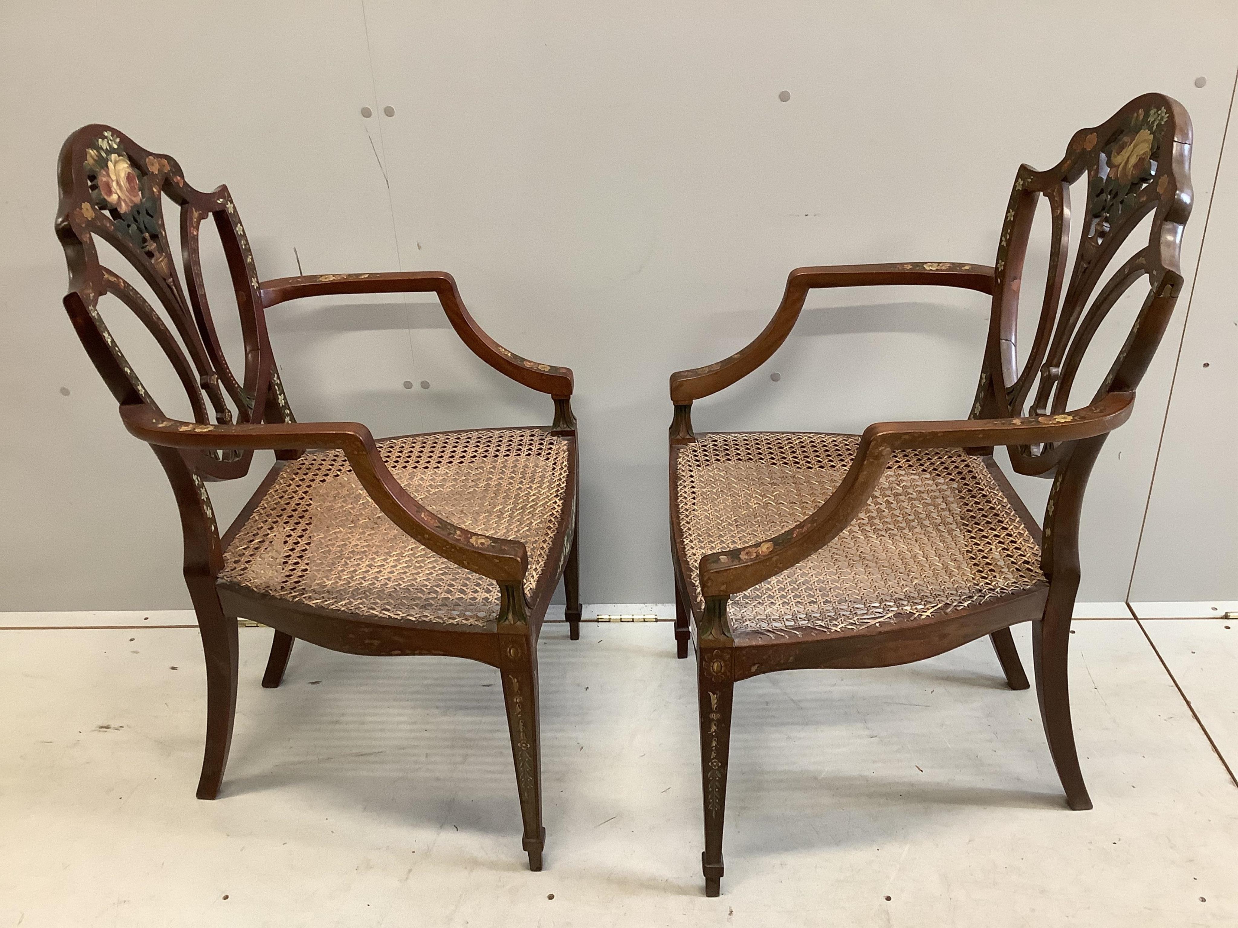 A pair of Edwardian Sheraton Revival painted satinwood elbow chairs, width 51cm, depth 48cm, height 96cm. Condition - fair